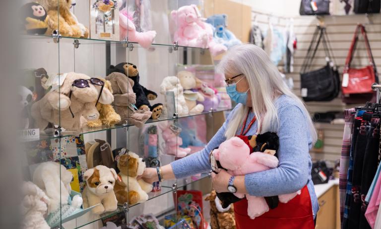 person stocking shelves in Richmond hospital gift shop