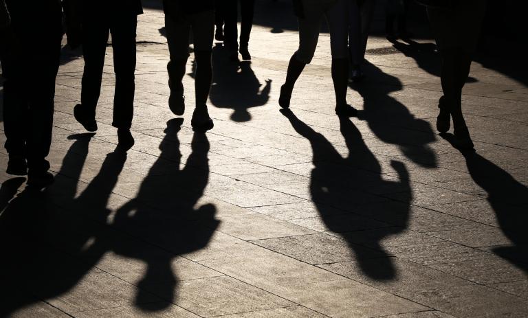 Black silhouettes and shadows of people on the street