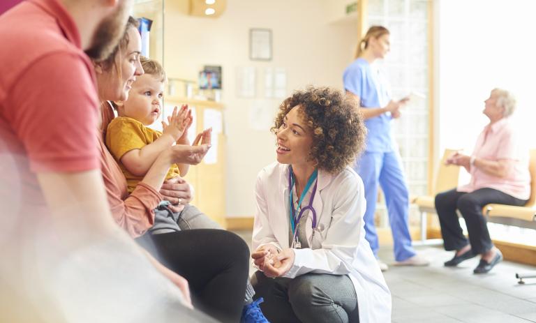 Female doctor talking to toddler