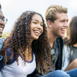 Four youth smiling for a picture outside.