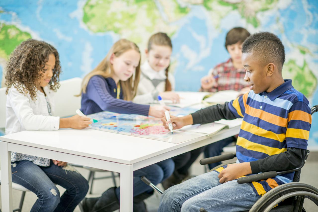 five children working on schoolwork in a classroom
