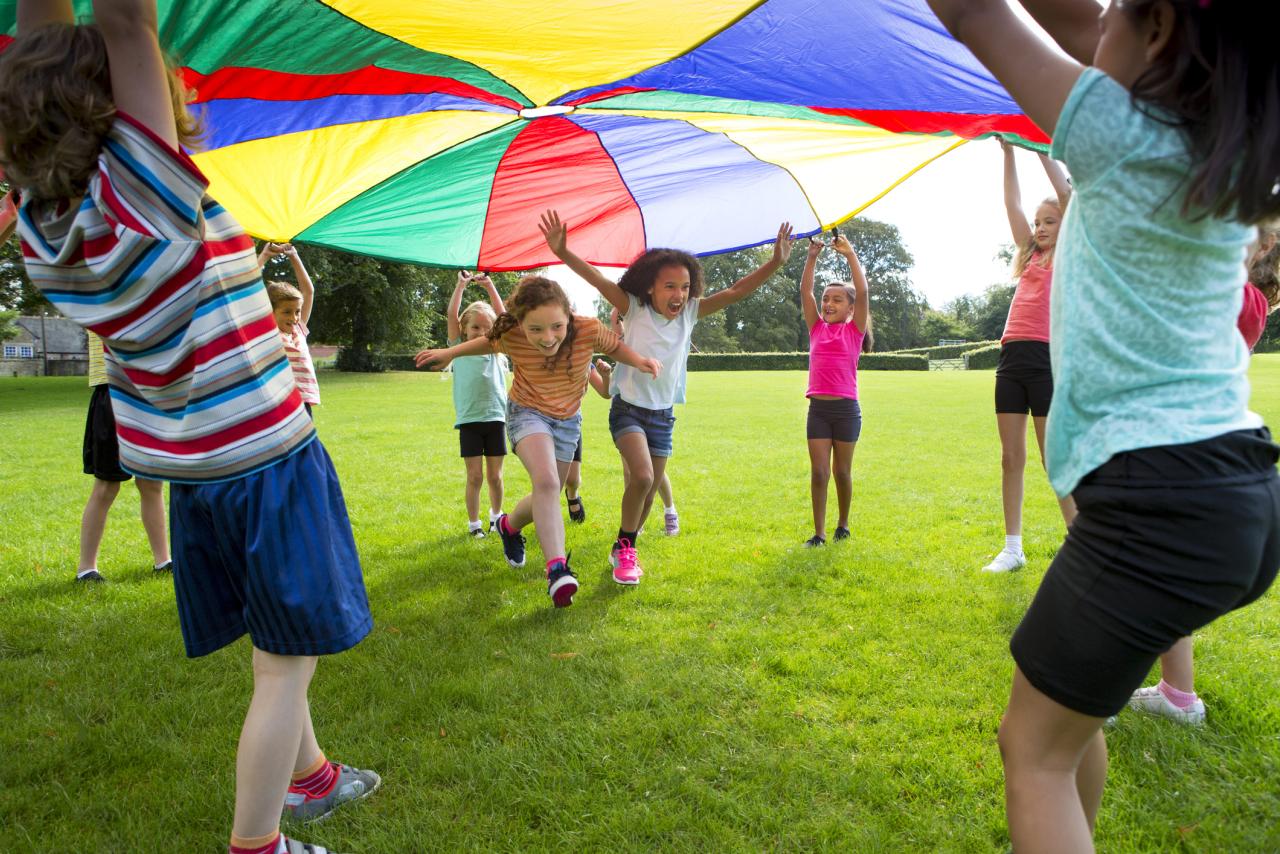 Children playing outside with a parachute