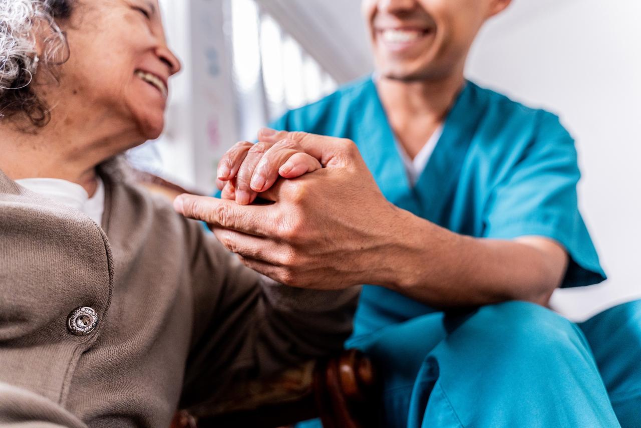 Senior woman holding caregiver's hands
