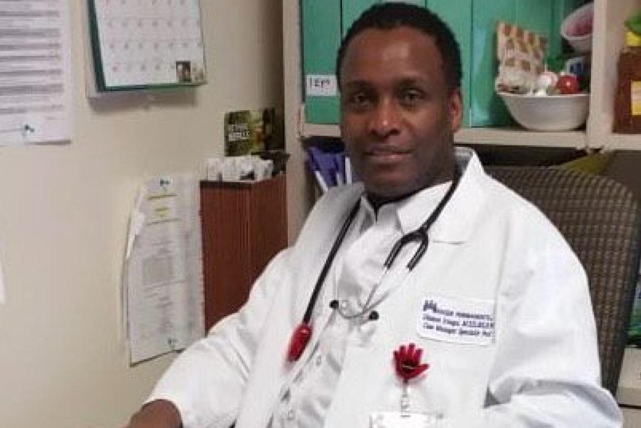 A nurse practitioner in a white medical lab coat with a stethoscope around his neck