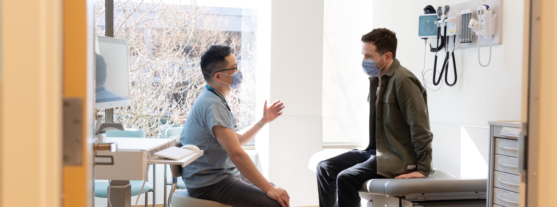 Health professional talking to patient in an exam room.