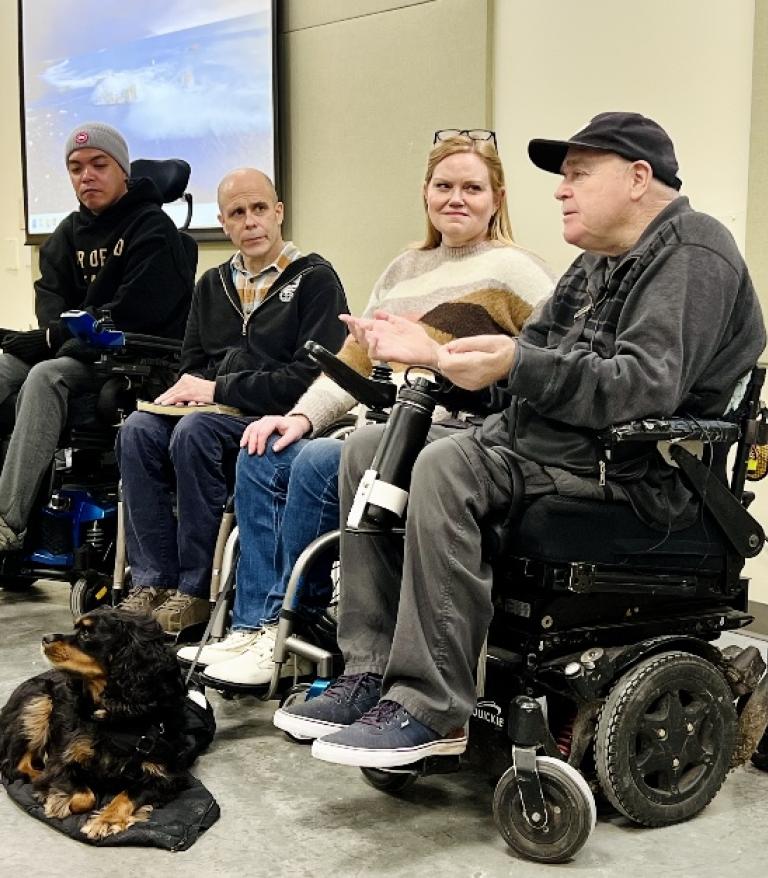 4 people in wheelchairs in a panel at a health forum 