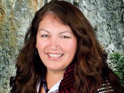 Portrait of Deborah Baker in front of a natural background.
