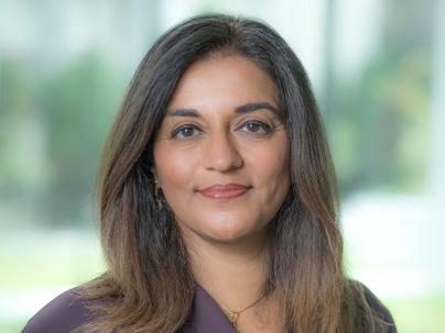 A portrait of Yasmin Jetha indoors.  She is wearing a purple shirt