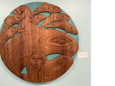 Indigenous wooden carving mounted on a white wall