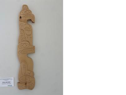 Indigenous wooden carving mounted on a white wall